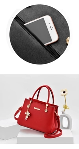 Dettaglio della borsa in pelle rossa con logo dorato e tasca posteriore con zip