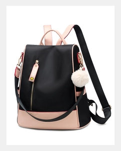 Detail of waterproof black nylon backpack with pink leather trim and gold zippers