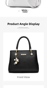 Dettaglio di borsa a mano minimalista in pelle con logo dorato e ciondolo a fiore