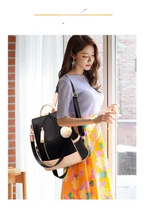 Detail of waterproof nylon backpack with heart zipper and plush ball charm in casual style