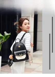 Détail du sac à dos bicolore noir et blanc avec breloque cerf et pompon marron