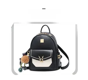 Détail d'un sac à dos en cuir bicolore avec ornement de cerf doré et breloque peluche