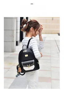 Détail d'un grand sac à dos en cuir PU noir avec logo cerf doré et breloque en peluche