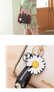 Detail of elegant patterned handbag with floral charm and branded shoulder strap
