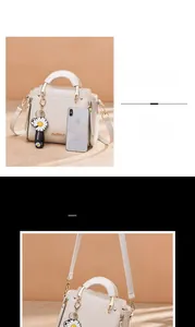 Detailed view of white PU leather handbag with daisy charm and phone size comparison
