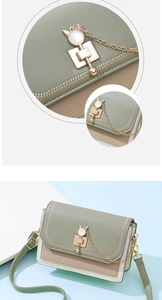 Detail of color-block crossbody bag with cat lock, herringbone stitching and leather texture