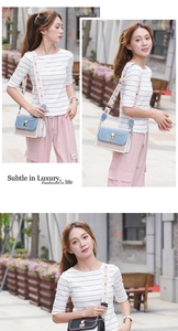 Detail of trendy crossbody bag with wide embroidered strap and pearl chain charm