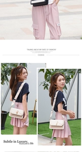 Detail of off-white leather crossbody bag with metal chain and floral wide strap