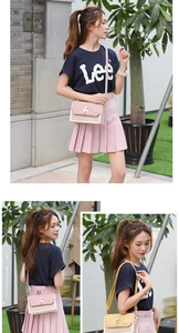 Detail of color-block crossbody bag featuring golden cat metal buckle and chain decoration