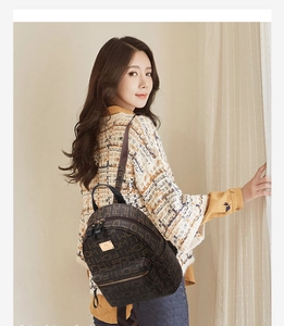 Detailed side view of fashion backpack featuring classic letter print and gold logo plate