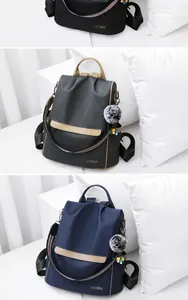 Dettagli di zaini in nylon impermeabile in nero, grigio e blu con ciondoli decorativi pompon