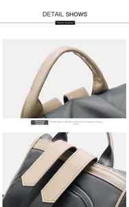Detail of ergonomic stitched handle and wide shoulder straps on grey oxford backpack