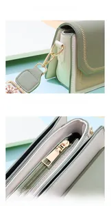 Detail of light green leather bag showing gold hardware and embroidered wide strap
