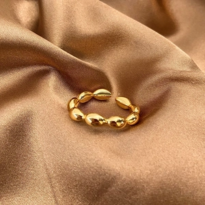 Macro detail of French vintage gold twist open ring on elegant brown silk fabric