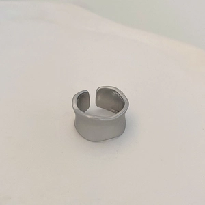 Vue détaillée d'une bague large argentée mate aux bords ondulés élégants