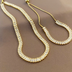 Adjustable gold plated jewelry set featuring baguette cut cubic zirconia stones