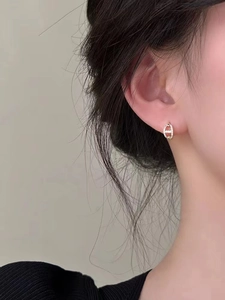Close-up of elegant gold hollow pave zircon earrings worn on a model ear