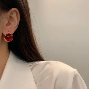 Gros plan de boucles d'oreilles rubis rouges de style français avec bordure dorée
