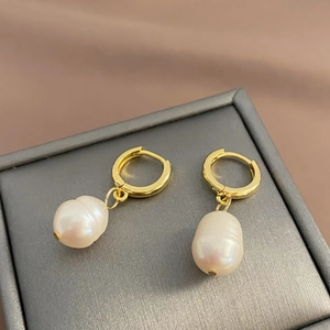Detail of baroque freshwater pearl earrings with gold-plated rings on luxury box