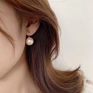 French style cotton pearl earrings with gold plating on model in a minimalist side view