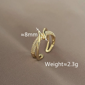 Detail view of crossover ring showing 8mm width and 2.3g weight on fabric background