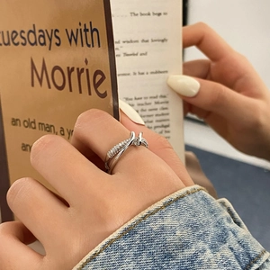 Minimalist silver double-layered crisscross ring featuring micro-pave cubic zirconia accents