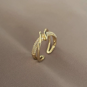 Close-up of gold wrap ring featuring sparkling micro-pave crystals on a textured fabric