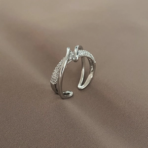 Macro detail of criss-cross ring showing pavé-set stones and polished silver finish