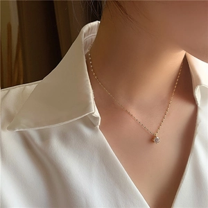 Détail d'un collier pendentif en cristal brillant avec finition plaquée or sur un mannequin