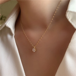 Détail d'un collier doré élégant avec pendentif en zircon brillant de taille ronde