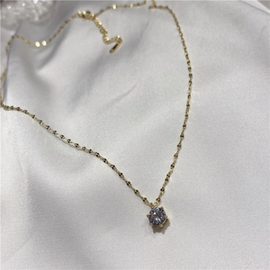 Collier élégant plaqué or avec pendentif solitaire brillant sur fond de soie