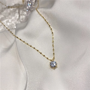 Vue détaillée d'un pendentif en zircon rond sur une fine chaîne plaquée or élégante