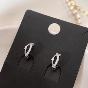 Vue détaillée de boucles d'oreilles croisées argentées serties de zircons cubiques