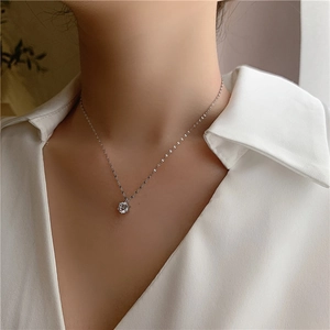 Gros plan d'un collier avec pendentif solitaire en zircon sur un mannequin en blanc