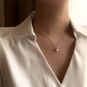 Gros plan d'un collier en argent minimaliste avec un pendentif brillant en zircon rond