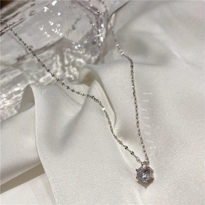 Vue détaillée d'un collier minimaliste argenté avec un zircon brillant serti de six griffes