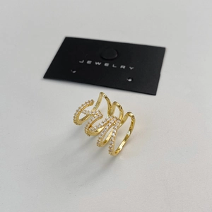 Detailed view of multilayer gold wave ring micro-paved with sparkling zircons on a jewelry card