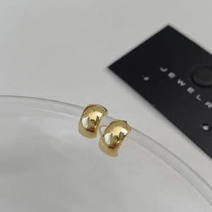Detailed view of chunky gold hoop earrings with a high-polish finish on a display card