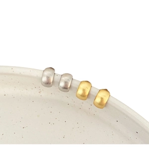 Minimalist brushed metal bean stud earrings in gold and silver finish for women