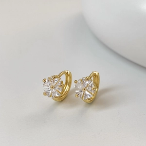Detailed close-up of gold flower huggie hoop earrings with sparkling zircon crystals