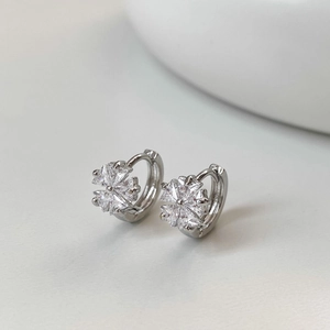 Macro detail of silver flower hoop earrings with marquise-cut sparkling zircons