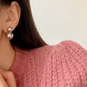 Elegant silver double sphere earrings with mirror polish finish on a female model