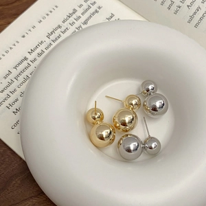 Minimalist double sphere stud earrings set in polished gold and silver finish
