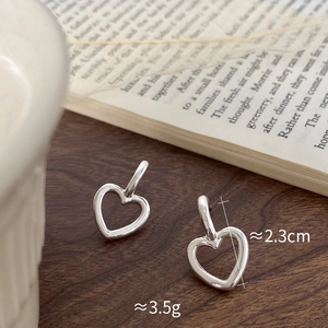 Détail macro des boucles d'oreilles cœur argentées avec dimensions de 2,3 cm et 3,5 g