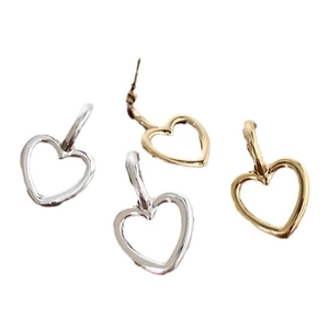 Boucles d'oreilles cœur évidé minimalistes en or et argent sur un fond blanc uni