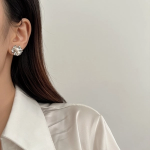 Détail de la boucle d'oreille fleur argentée avec deux perles sur le mannequin