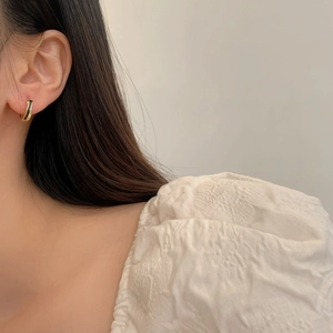 Minimalist gold-plated hoop earrings with black enamel detail on female model