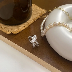 Detailed view of silver knot ring with sparkling zircon stones on a vintage display