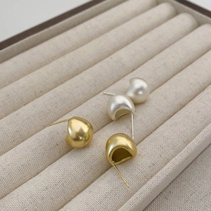Elegant matte gold and silver water drop earrings displayed in a jewelry box