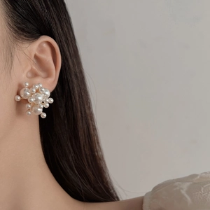 Elegant cluster pearl stud earrings with gold plating shown on model in a close-up view
